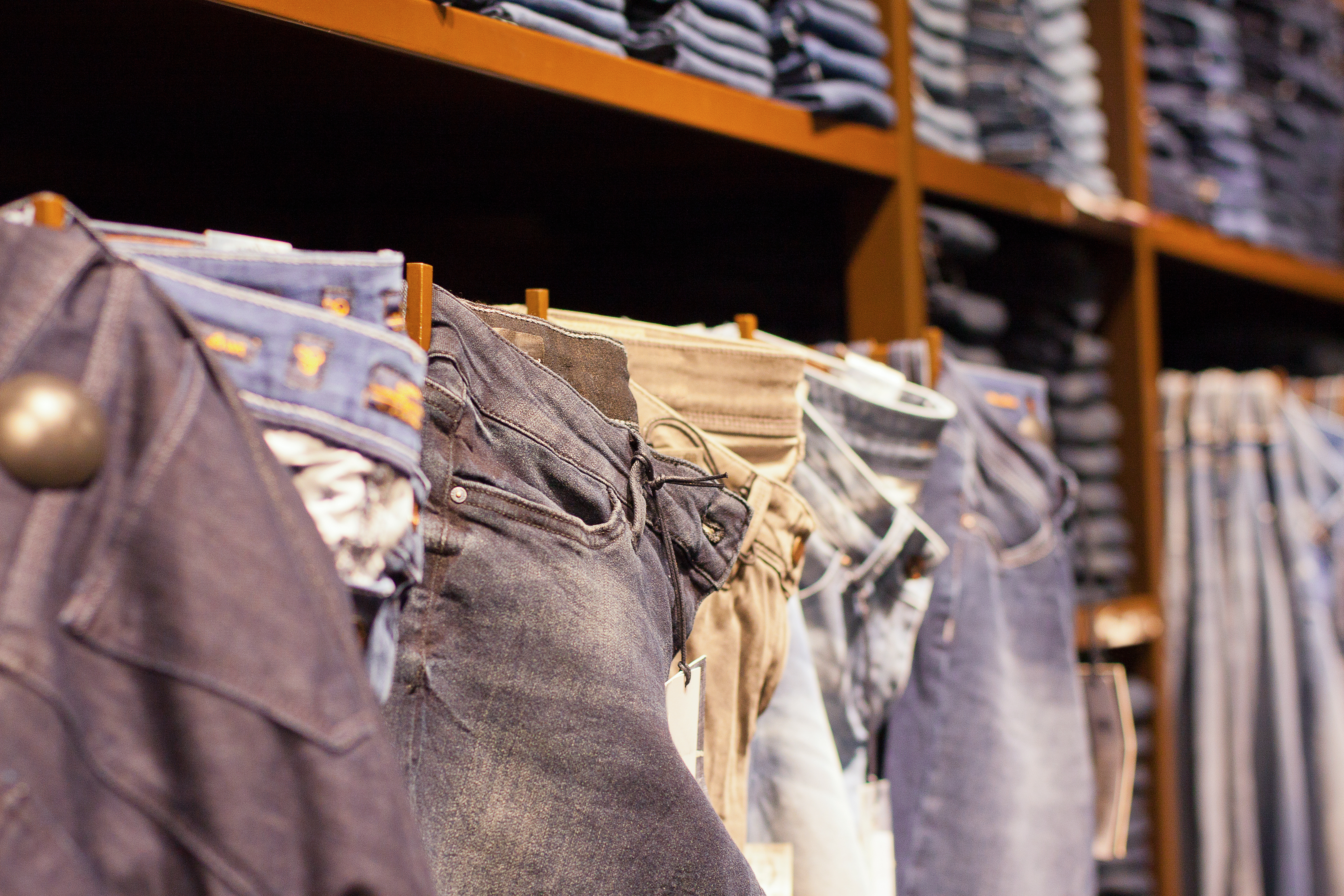 Fashion clothes on shelves in store. - Denim Hacker